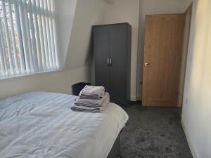 a bedroom with a bed and a cabinet and a door at 1 Bed City Centre Apartment in Derby
