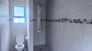 bagno bianco con servizi igienici e finestra di 3 Bed - Modern Retreat with Stay-in helper a Bloemfontein Altre 11 foto