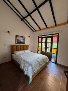 a bedroom with a bed and stained glass windows at Monguí Posada Familiar in Duitama