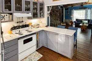een keuken met witte apparatuur en een woonkamer bij Cabin By The Trees in Warren