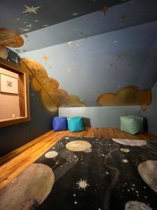 a room with a ceiling with clouds and a rug at Powderhorn Hideaway in Auvinen Corner