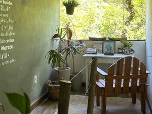 a desk with a chair in a room with plants at Suites casa do indio jungle, a melhor vista da floresta in Abraão