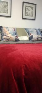 eine rote Decke auf einem Bett mit zwei Kissen in der Unterkunft Aveiro Ria View in Aveiro