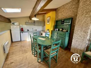 eine Küche mit einem grünen Tisch und Stühlen in der Unterkunft La marelle in Villerouge-Termenès