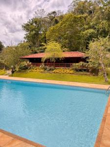 a large swimming pool in front of a house at Pousada Tucano Do Cuiabá in Itaipava