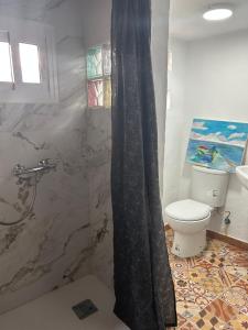 een badkamer met een douche, toilet en wastafel bij Bujanvilla in Tarifa