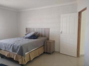 a bedroom with a bed with blue pillows on it at Bafokeng Palace in Mid-Ennerdale