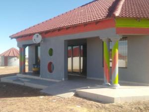 a small house with a clock on the side of it at Bafokeng Palace in Mid-Ennerdale