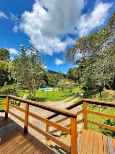 a wooden deck with a view of a park at Pousada Tucano Do Cuiabá in Itaipava +96 photos