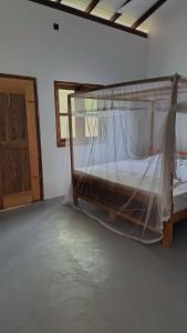 une chambre avec un lit avec moustiquaire dans l'établissement My House Ahangama, à Ahangama