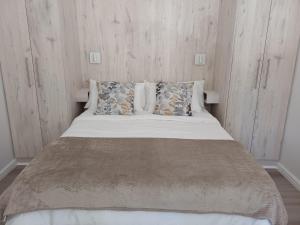 une chambre avec un lit avec des draps blancs et des oreillers dans l'établissement Cosy comfort, à George