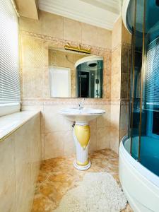 a bathroom with a sink and a mirror and a tub at Ember Residence Spacious 2BR Apartment near Eternal Flame in Sarajevo +10 photos