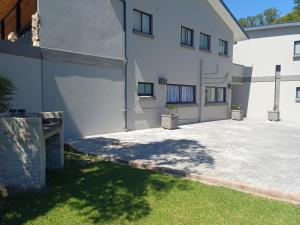 une cour d'un bâtiment blanc avec une terrasse dans l'établissement Cosy comfort, à George