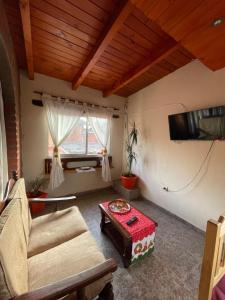 een woonkamer met een bank en een tafel bij Departamento Ayllu IV in Tilcara