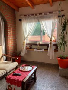 een woonkamer met een tafel en een raam bij Departamento Ayllu IV in Tilcara +5 foto's