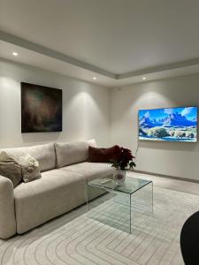 a living room with a couch and a glass table at Tromso Panorama in Tromsø