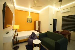 a small room with a bed and a couch at Buddha Premium Stays in Guwahati +78 photos