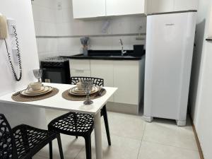 een keuken met een tafel, stoelen en een koelkast bij Espaço completo Bauru in Bauru +14 foto's