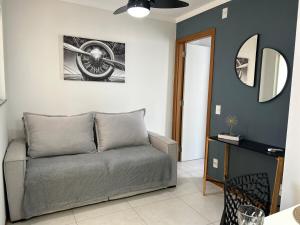 een woonkamer met een bank en een spiegel bij Espaço completo Bauru in Bauru