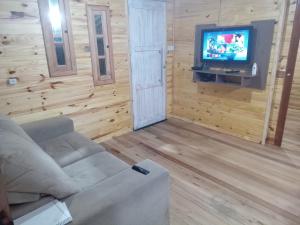 un soggiorno con divano e TV a schermo piatto di Morada do Verão a Imbé