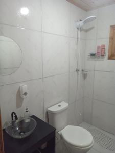 un bagno bianco con un water e un lavandino di Morada do Verão a Imbé