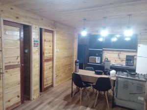 una cucina con pareti in legno, tavolo e sedie di Morada do Verão a Imbé