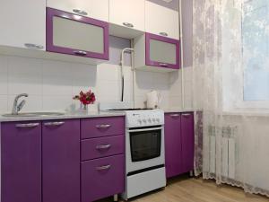 a kitchen with purple cabinets and a sink at Nectar Apartments in Aktobe