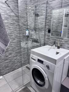 a washing machine in a bathroom with a shower at Saulgrieži 7 in Ventspils +8 photos