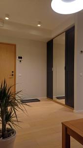 an empty room with a potted plant and a mirror at Keila Round View Apartment in Keyla +4 photos