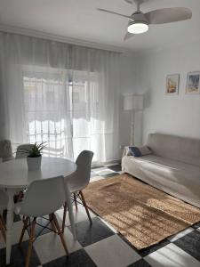 een woonkamer met een tafel en een bank bij Apartamento Clavel in Chipiona +9 foto's