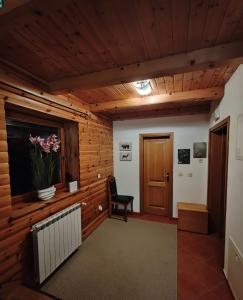 a room with a wooden wall with a plant on a window at Greenhouse Klara with heated pool in Tršće