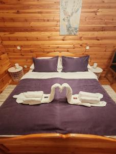 a bed with two pairs of towels on it at Greenhouse Klara with heated pool in Tršće +32 photos