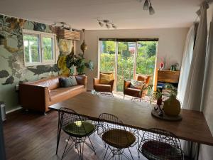 a living room with a couch and a table and chairs at Chalet Bosrand 42 Park Veluwshof 6 p in Hoenderloo