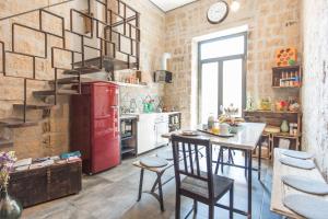 Il comprend une cuisine équipée d'un réfrigérateur rouge et d'une table. dans l'établissement Magma Home - Rooms & Roof, à Naples