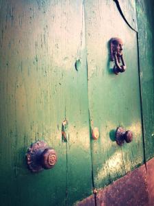 Una puerta verde con algunos picaportes. en Svegliarsi nei Borghi - La Patronale, en Troia