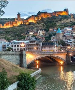 een brug over een rivier naast een stad bij Hotel Zaira in Tbilisi City +69 foto's