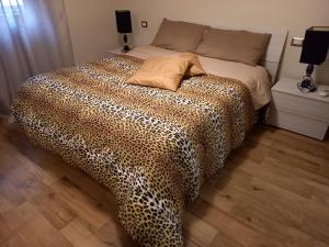 a bedroom with a bed with a leopard print blanket at Appartamenti Yolanda- Ideale per lavoro e relax in Rozzano
