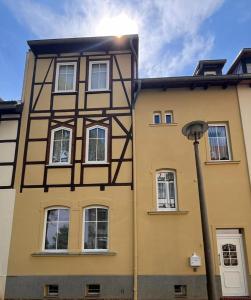 a yellow building with white windows and a street light at Mathilde in Quedlinburg