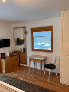 a living room with a table and a window at Bergkraft in Assling