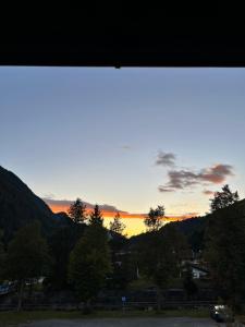 a sunset seen through a window with trees at Bergkraft in Assling