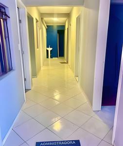a hallway of a room with a table in the distance at Quarto em Matinhos | Viva o Melhor do Litoral in Matinhos +4 photos