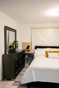 a bedroom with a black dresser and a mirror at Alojamiento completo familiar in Carolina