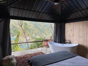 ein Schlafzimmer mit Badewanne und Blick auf die Berge in der Unterkunft Kainga in Puerto Vallarta