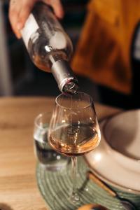 eine Person, die Wein in ein Weinglas gießt in der Unterkunft Maison Le Catelier in Le Catelier + 25 Fotos