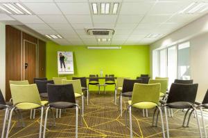 une pièce avec des chaises et une table et des murs verts dans l'établissement ibis Styles Saumur Gare Centre, à Saumur