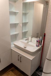 een witte badkamer met een wastafel en een spiegel bij Apartman Nana in Vranje +8 foto's
