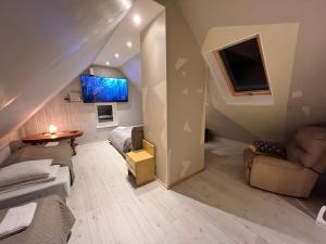 a living room with a couch and a tv at Ader puhkemaja in Kogula