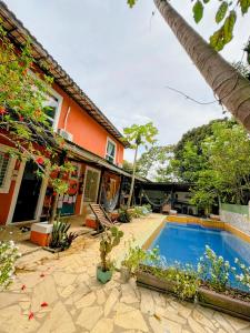 a house with a swimming pool in the yard at Vila Pepouze Hostel in Morro de São Paulo