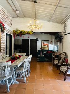 a dining room with a table and chairs and a chandelier at Finca el origen 2025 in Roldanillo