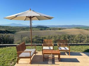 two chairs and an umbrella on a patio at Podere Stabbia in Rosennano